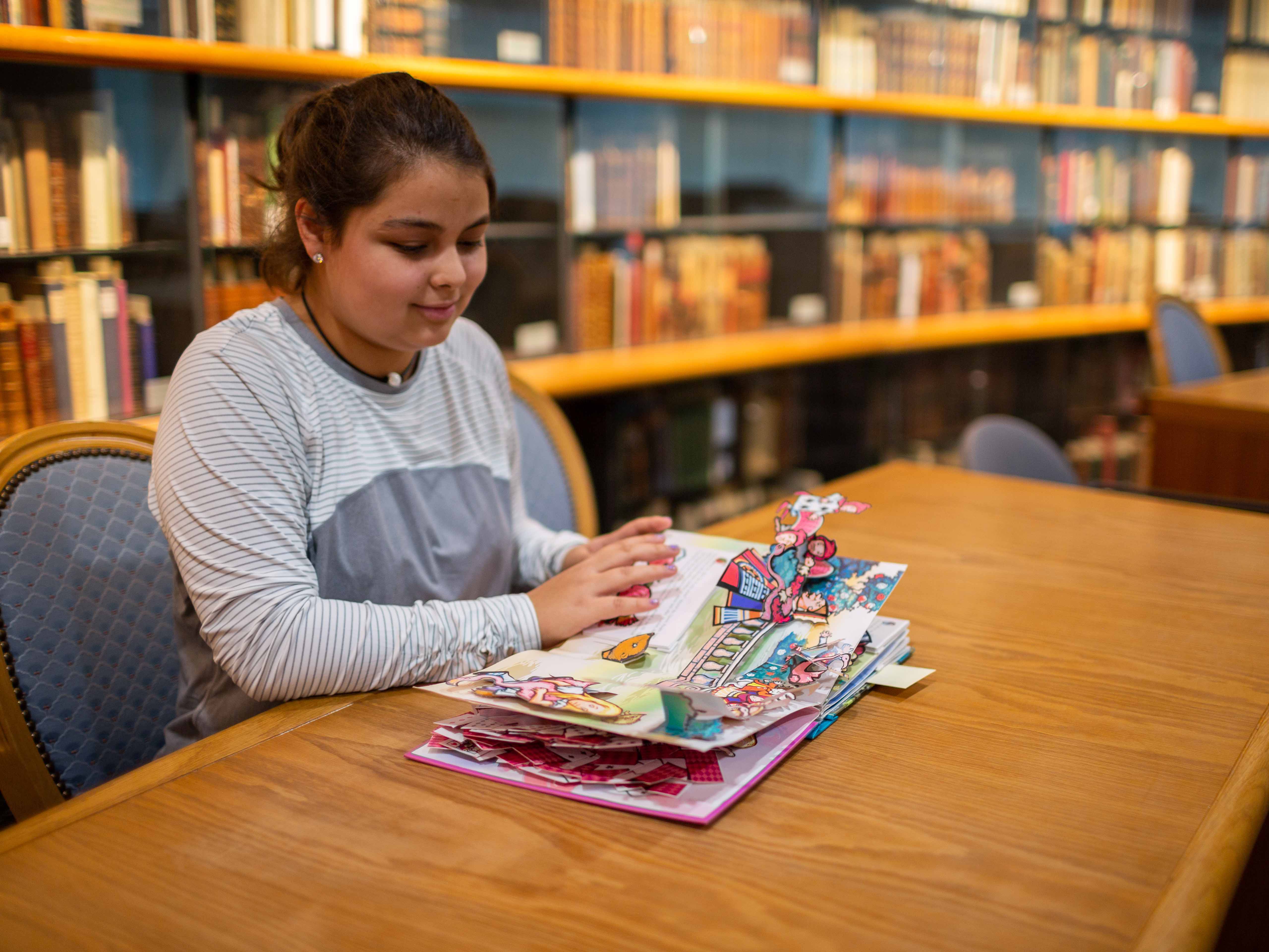 A student looks at a pop-up book