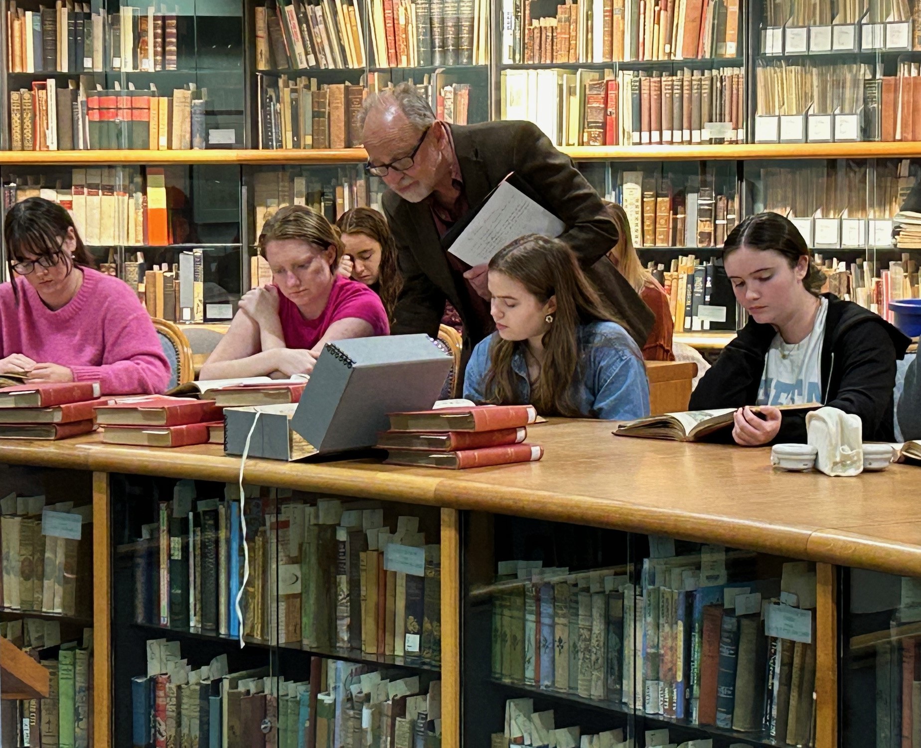 Prof. West and students look at books