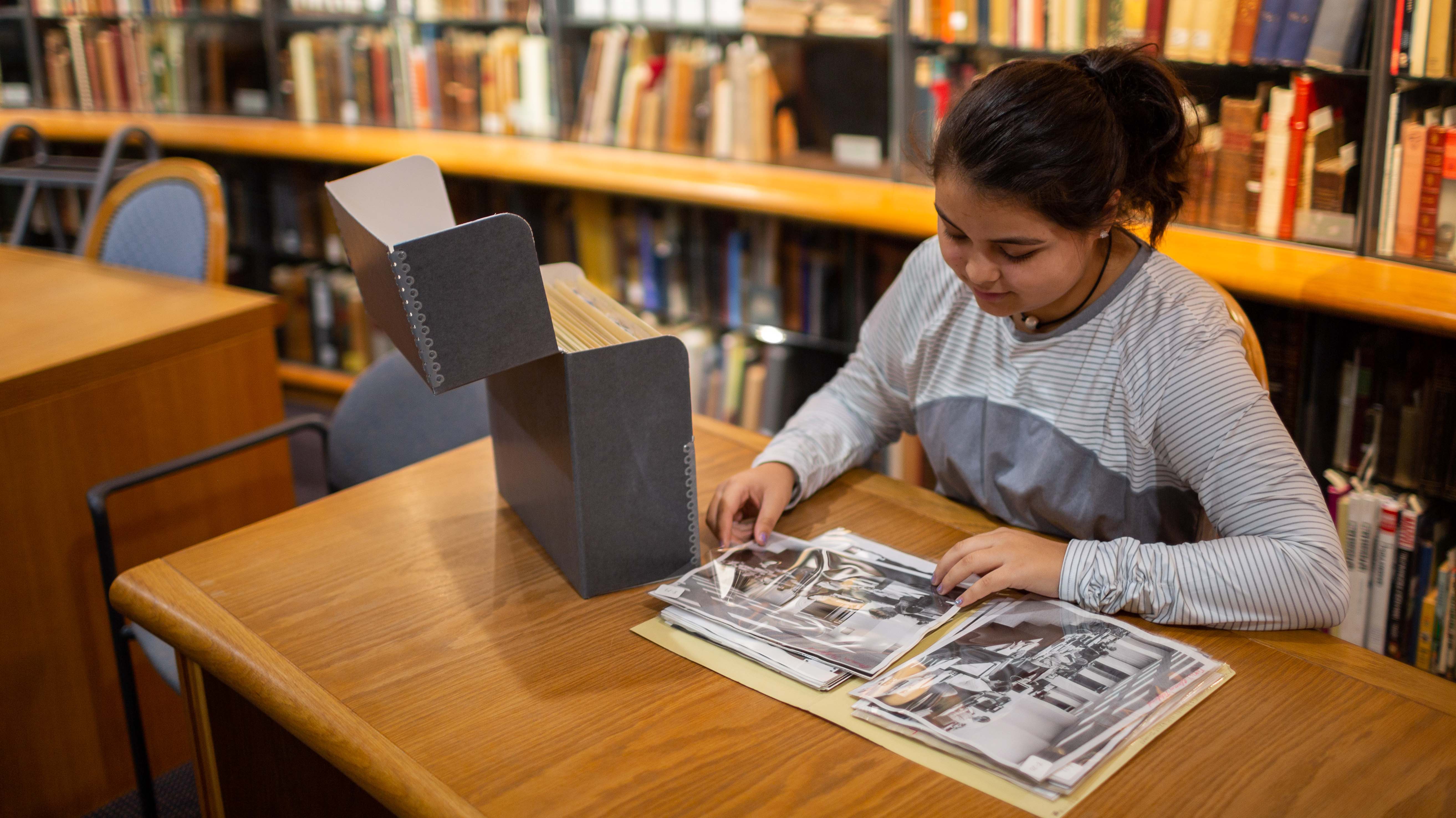 Student looking at photographs from the archives