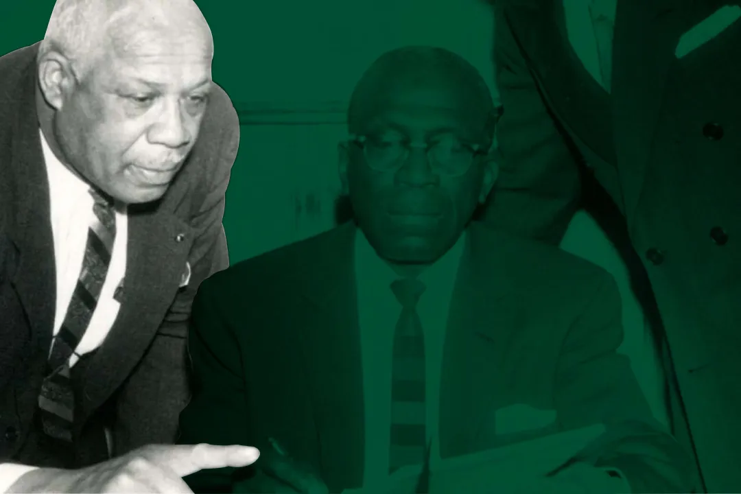 Charles McLean leaning over to talk to another man