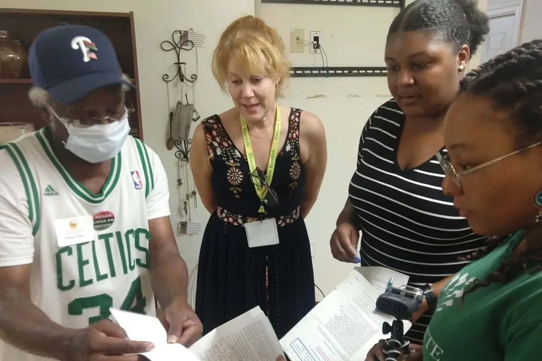A man shows three people some papers