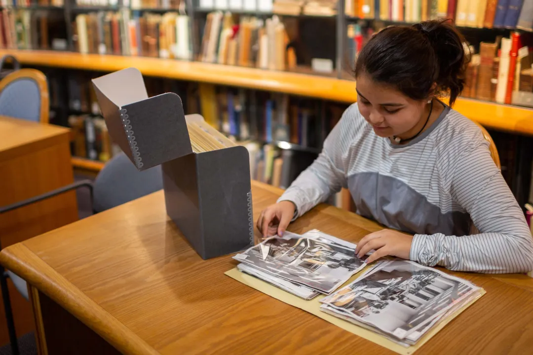 Student looking at photographs from the archives
