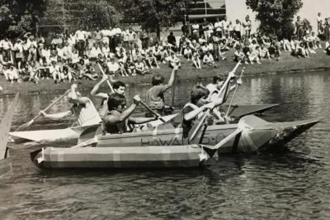 Students rowing handmade boats.
