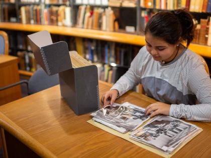 Student looking at photographs from the archives